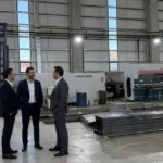 Savunma ve havacılık için fason lazer kesim yapılan üretim tesisinde makineler ve üretim alanını inceleyen yetkililer