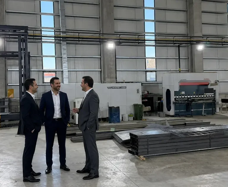 Savunma ve havacılık için fason lazer kesim yapılan üretim tesisinde makineler ve üretim alanını inceleyen yetkililer